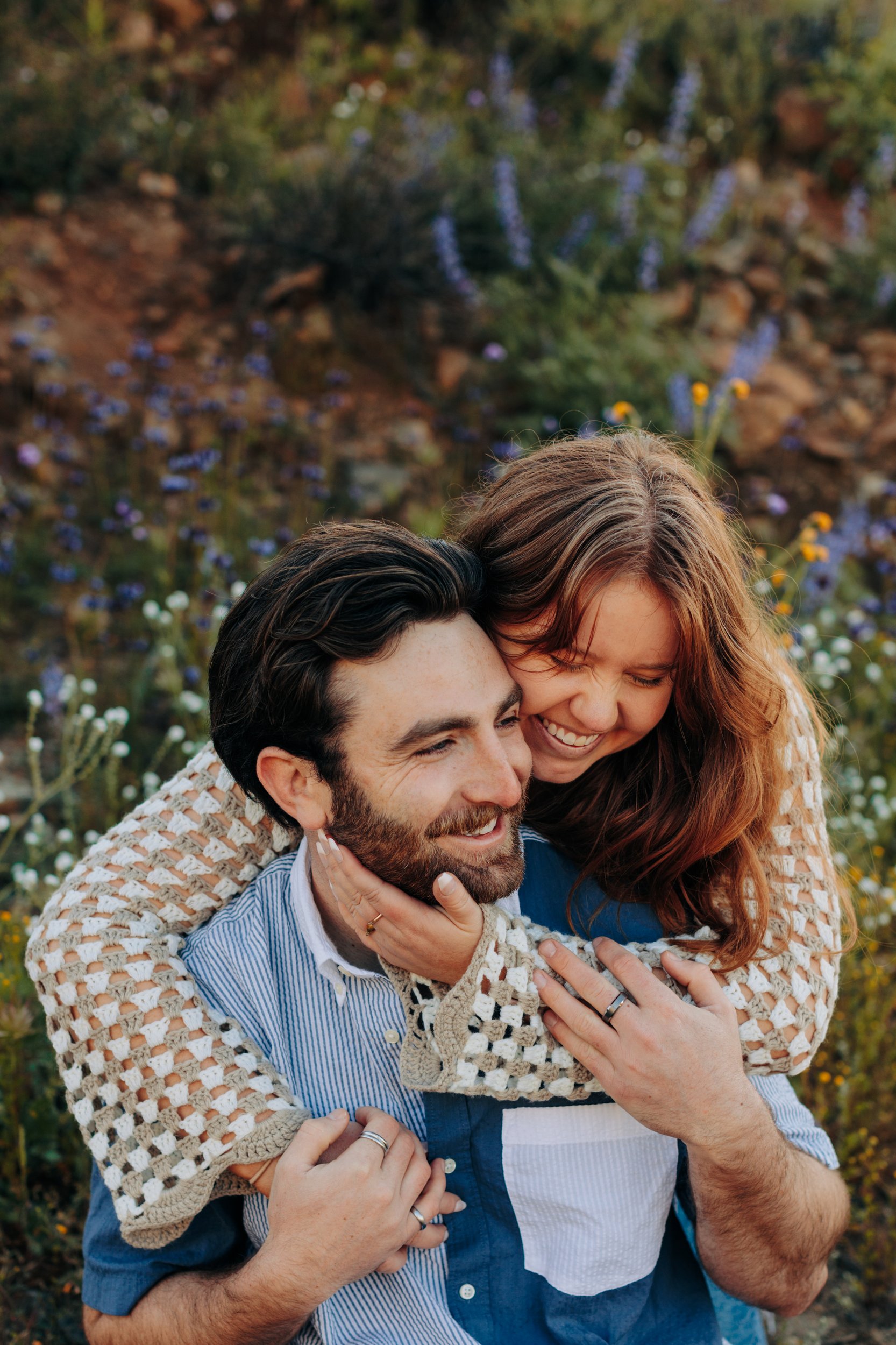 Couple embraces in a field of wildflowers